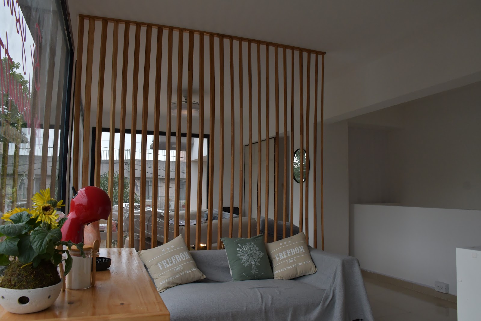 Interior del estudio Alejandra Indart Studio en Berazategui, sala de espera moderna con listones de madera y luz natural